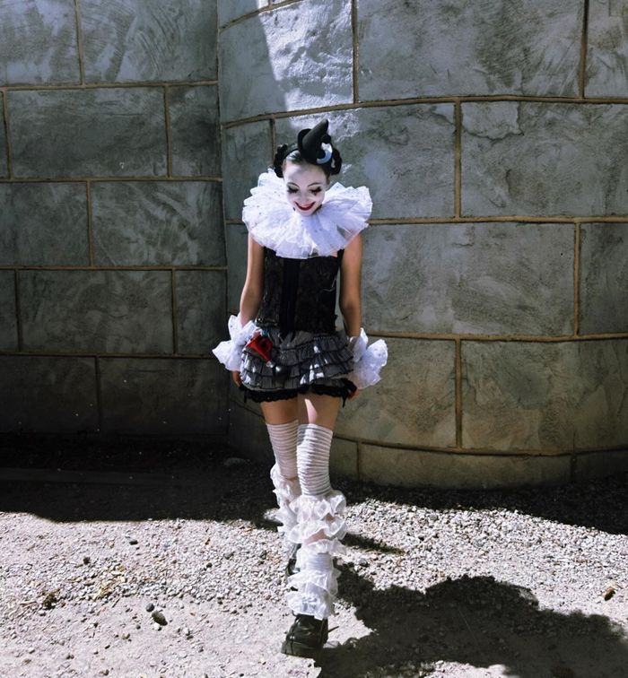 Hannah in a ruffled collar against a stone wall